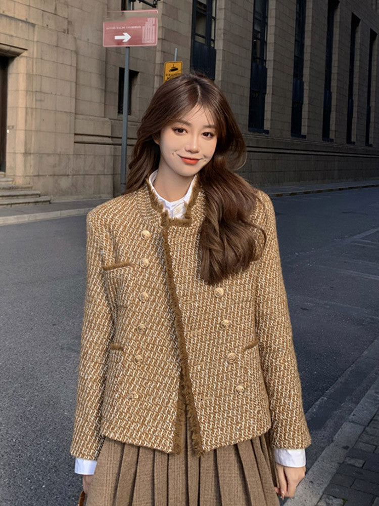 Tweed woolen jacket with gold button closure and long sleeves; paired with pleated skirt