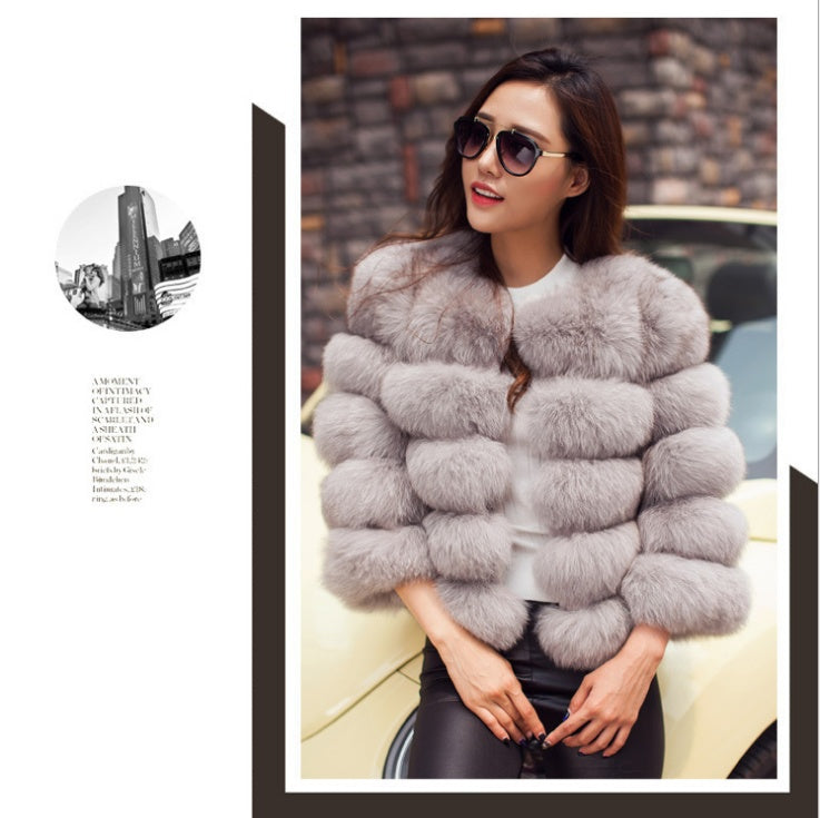 Women’s light gray fur jacket with rounded collar and thick layered panels.